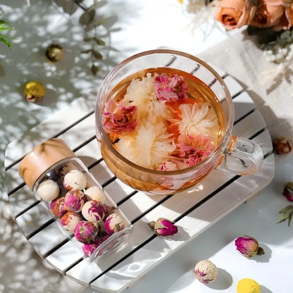 Organic whole chrysanthemum flower tea blooming in a clear glass cup, antioxidant rich herbal drink